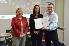 Uczestnik pozuje z dyplomem, obok pani z MSZ i dyrektor KSAP