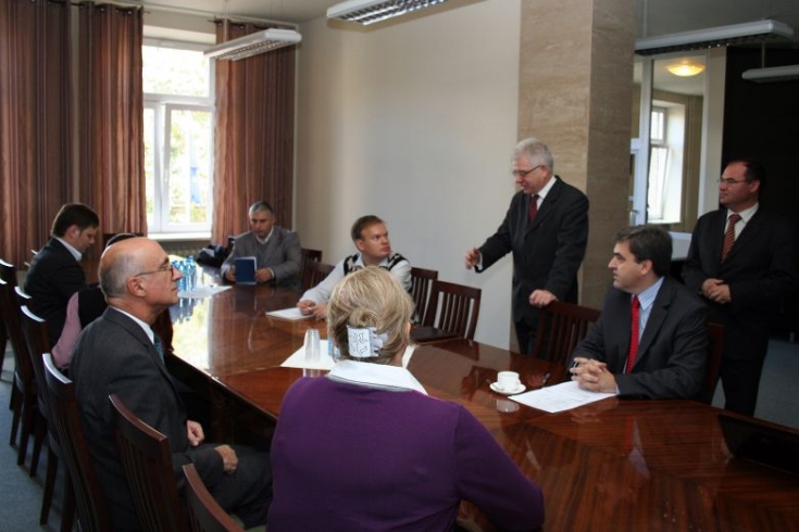 fot. Sebastian Szulfer/KSAP przedstawiciele Akademii Zarządzania Publicznego w Rotsowie siedza przy stole. Dyrektor KSAP stoi i mówi